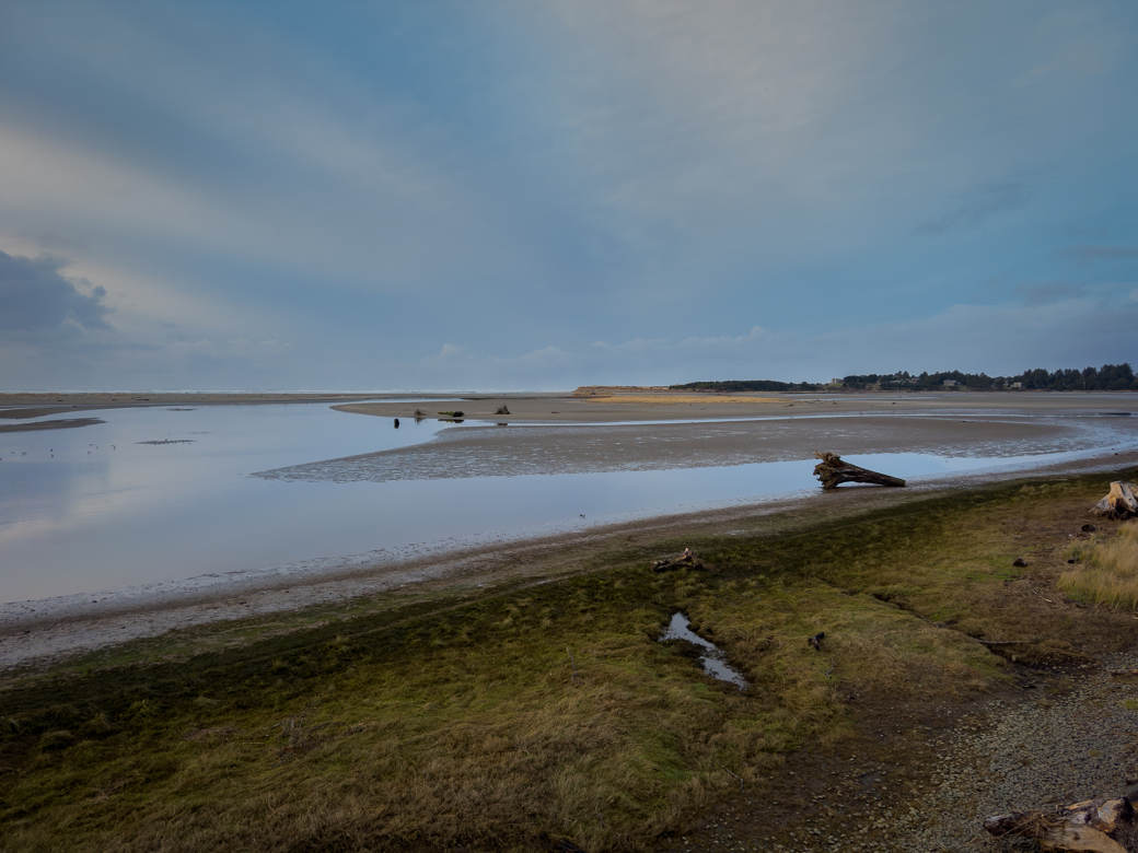 A sandy beach with a small body of water.