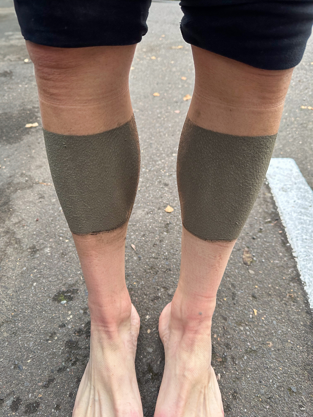Photograph of my shins completely covered in a thin layer of mud.  I was wearing leg warmers and shoe covers so there is a crisp line where the mud stops and my skin starts just below the knee and above my sock line